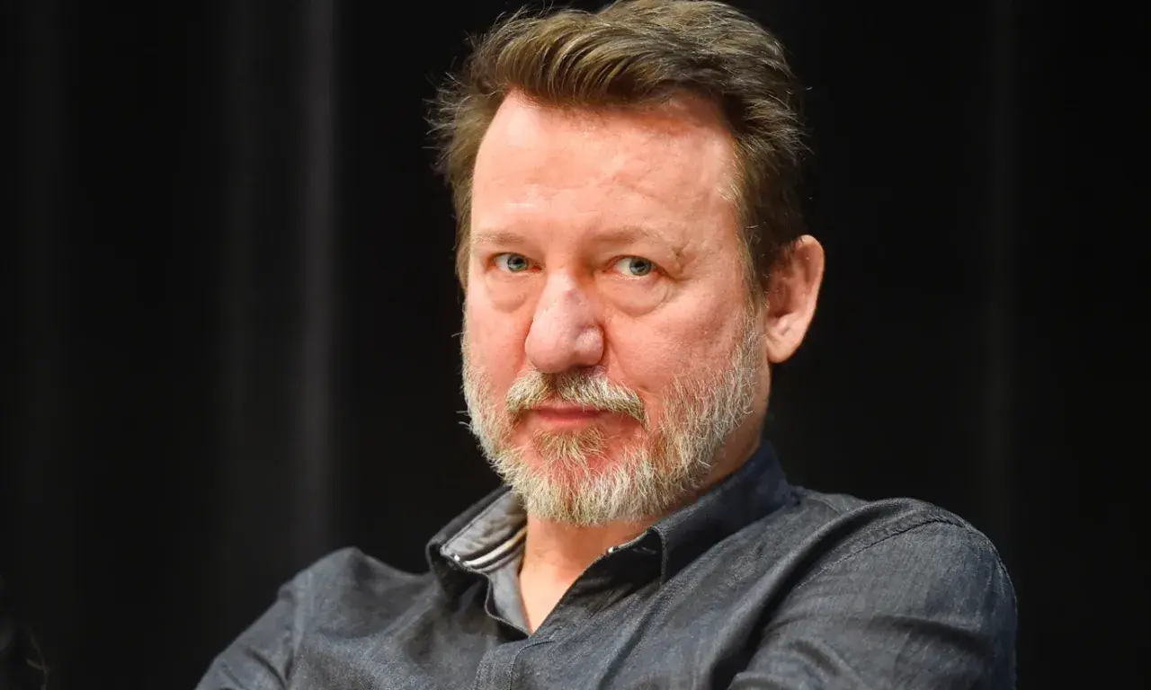 Robert Więckiewicz, znany z wielu filmów, seriali i programów, patrzy prosto w obiektyw.
