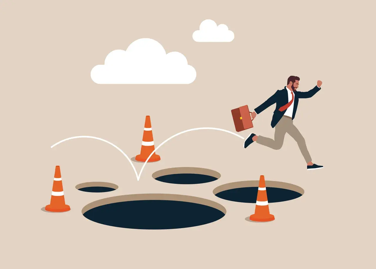 Un homme d'affaires saute par-dessus des trous, symbolisant les dangers du processus d'achat immobilier.