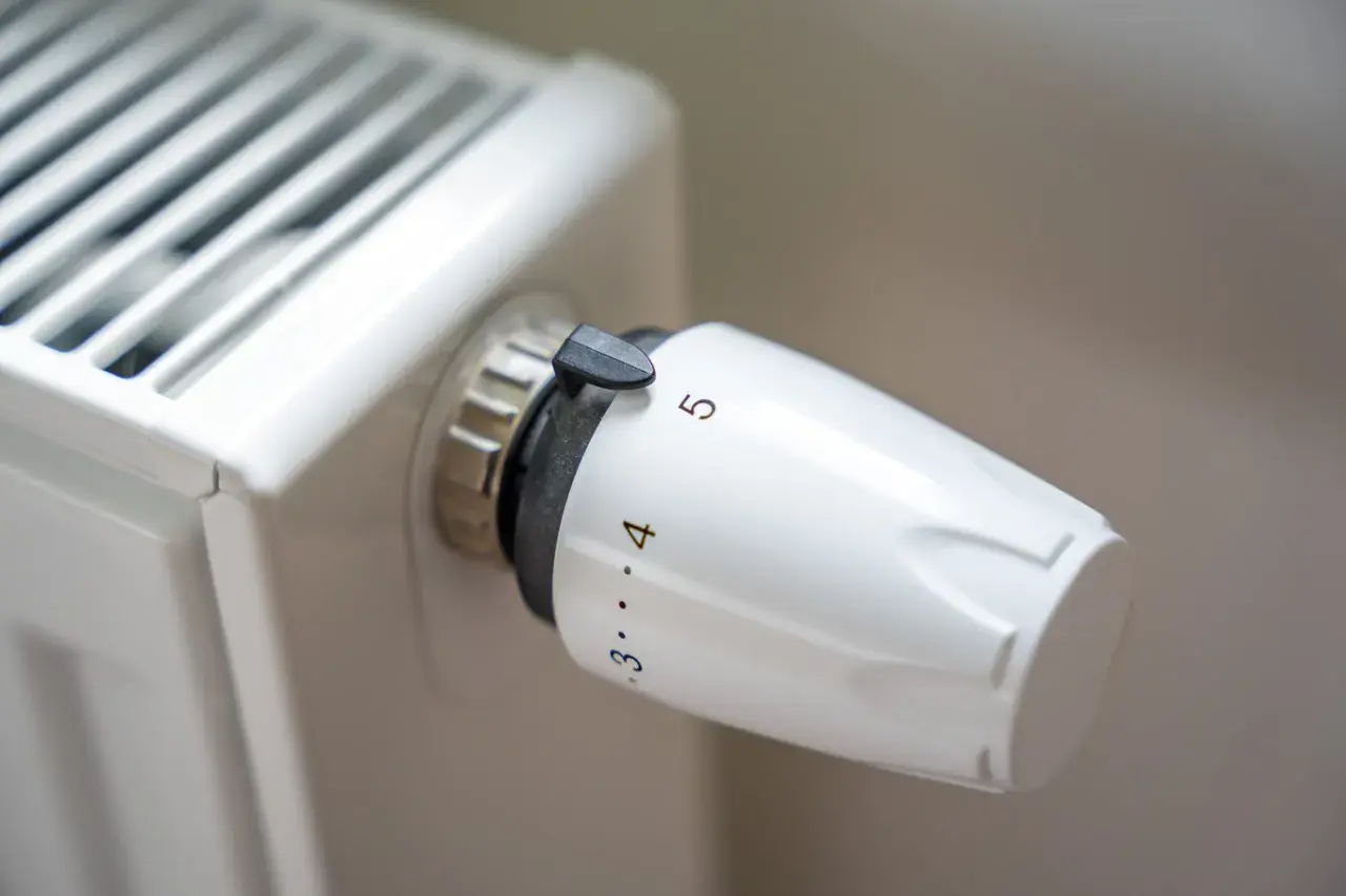 Pokrętło termostatu na grzejniku pokazuje, jak działa zawór termostatyczny, regulując temperaturę.