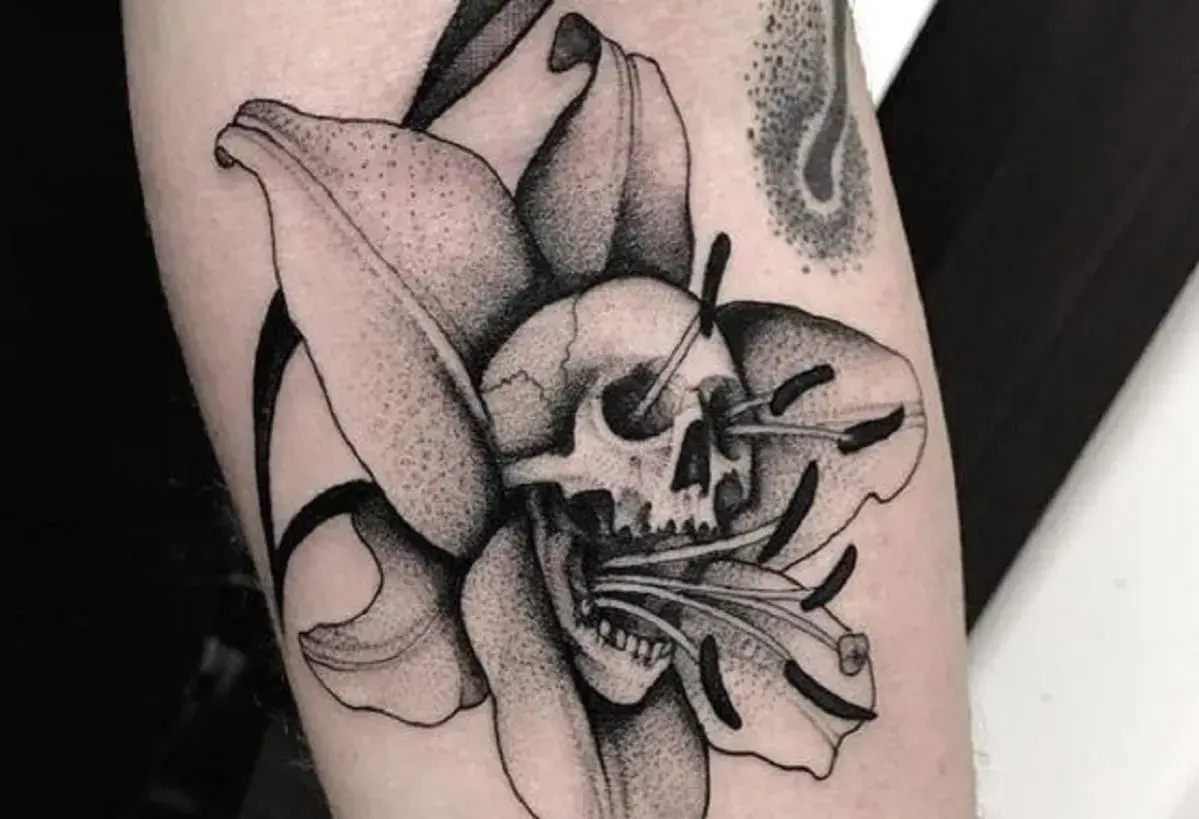 Tatuaże więzienne kropki: czaszka w lilii, symbolizująca przemijanie.