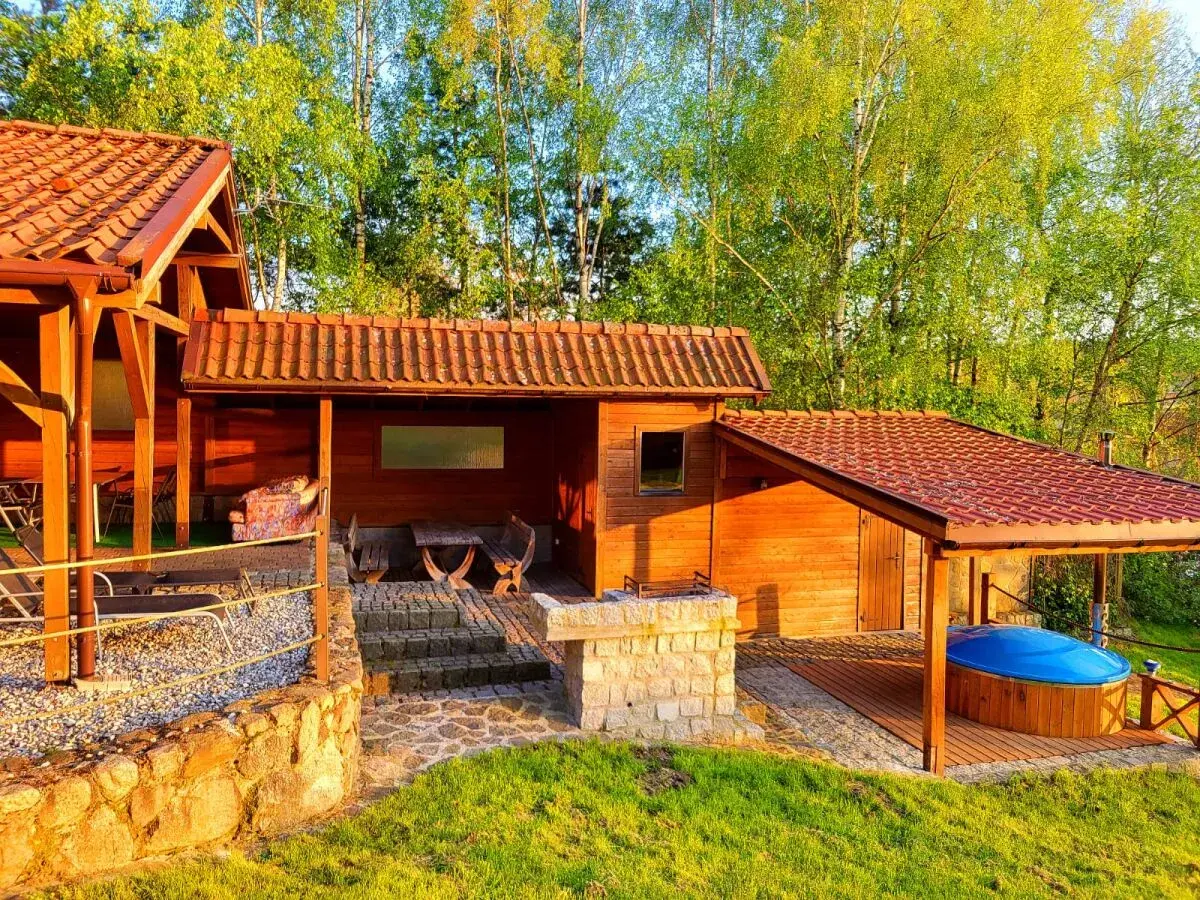 Drewniane domki na Mazurach z bali, zadaszone jacuzzi i grillem. Idealne na tani wypoczynek.