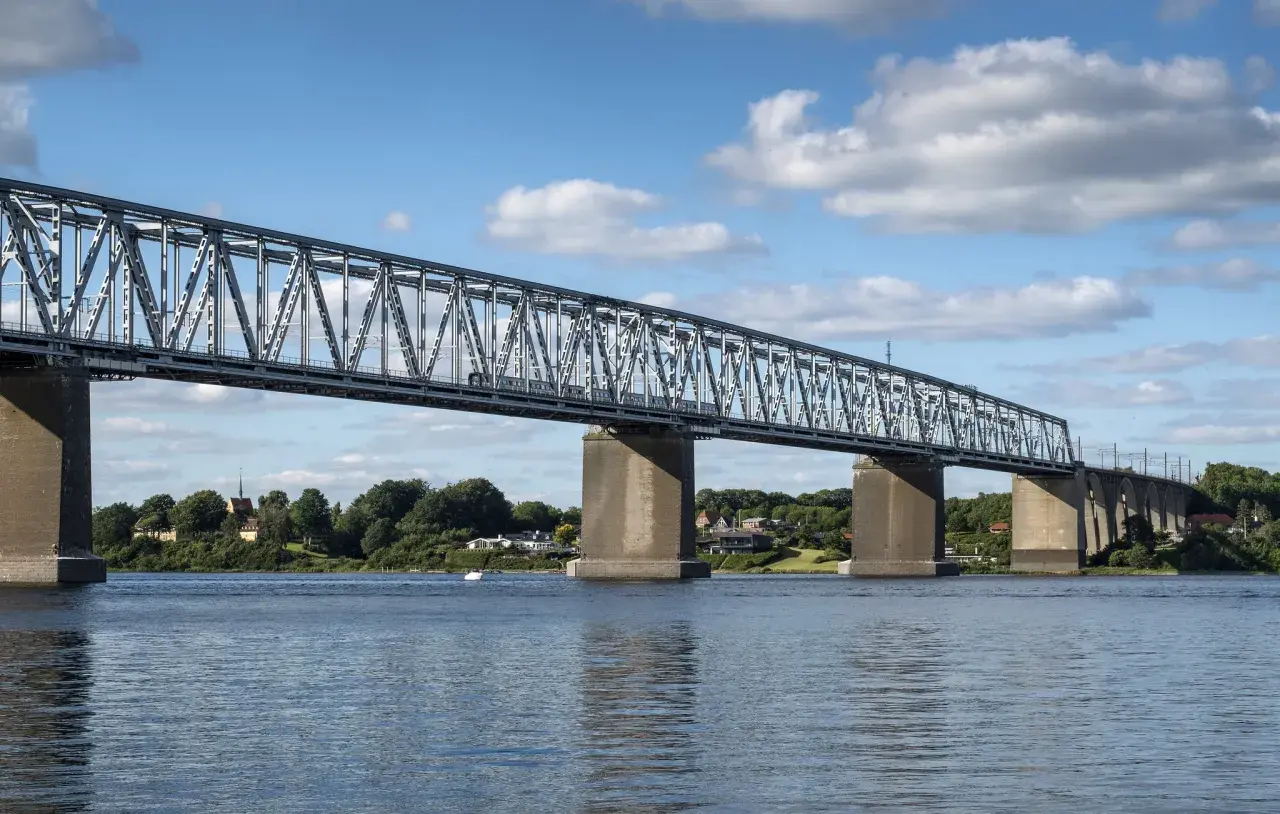 Lilla Bältbron, en imponerande järnvägsbro, sträcker sig över vattnet. Dess pris är väl värt den natursköna utsikten och den viktiga förbindelsen den utgör.