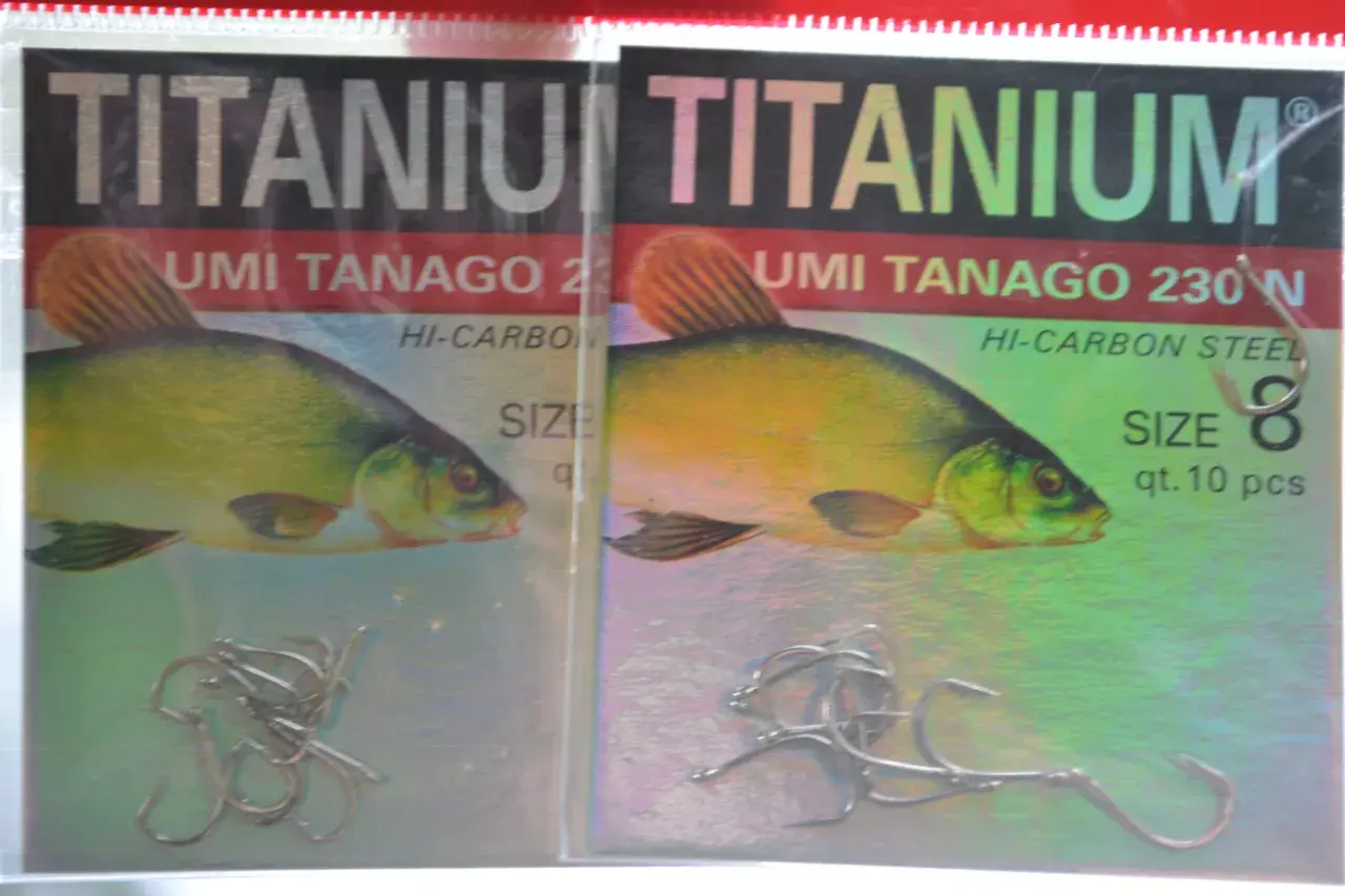Dwa opakowania haczyków wędkarskich "TITANIUM UMI TANAGO 230N" z wizerunkiem karasia.