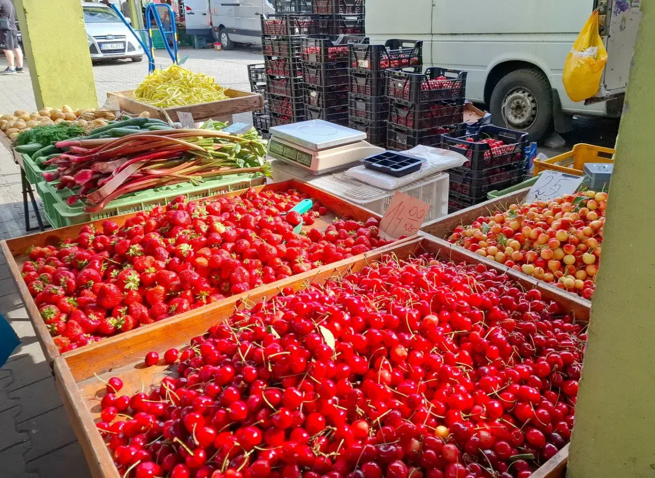 Targowisko pełne świeżych owoców. Duże skrzynie z truskawkami i czereśniami. Sprawdź czereśnie cenę za kilogram!
