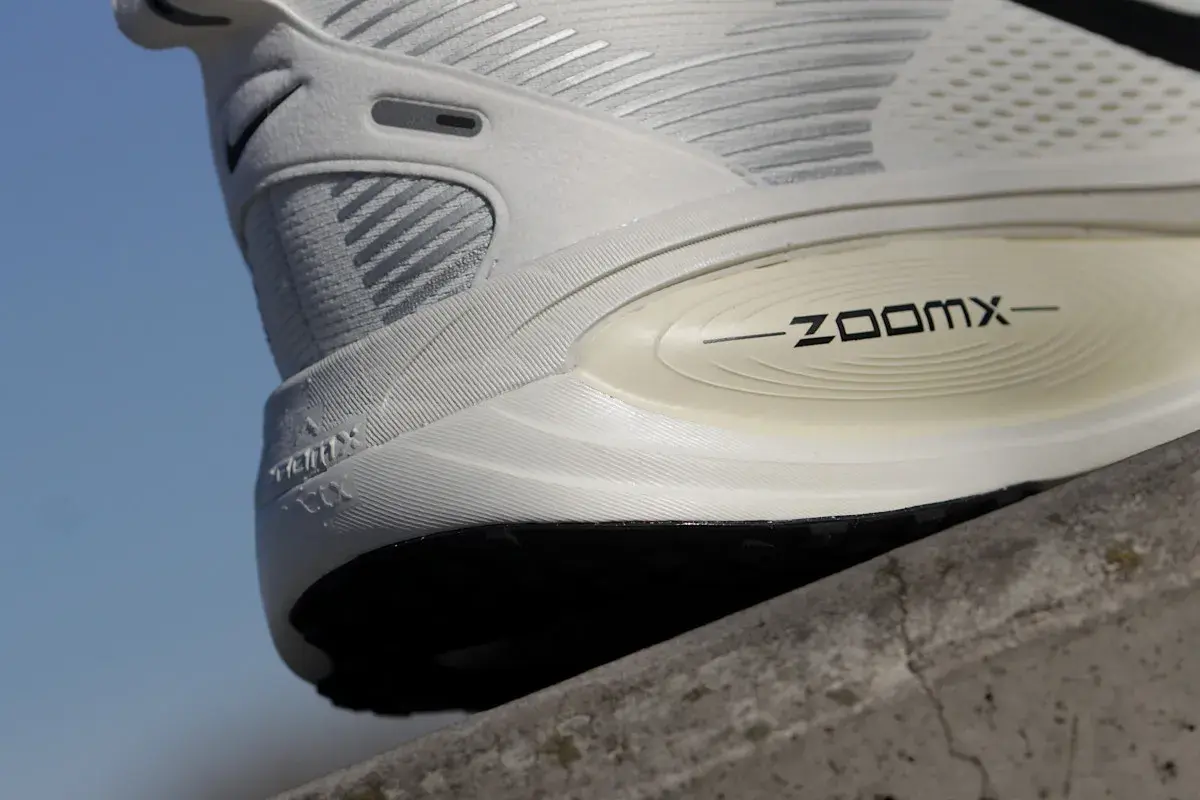Biały but sportowy z napisem ZOOMX. To jest ten słynny "drop" w butach, który wpływa na komfort biegu.