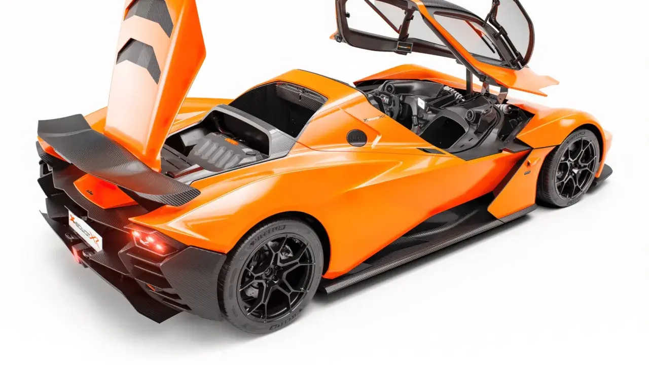 Pomarańczowy KTM X-Bow GT XR z otwartymi drzwiami i maską, ukazujący sportowy design i detale z włókna węglowego.