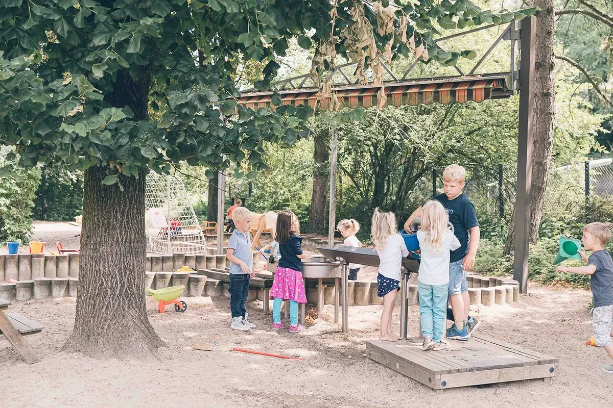 Kinder spielen im Sandkasten auf dem Gelände eines evangelischen Kindergartens.