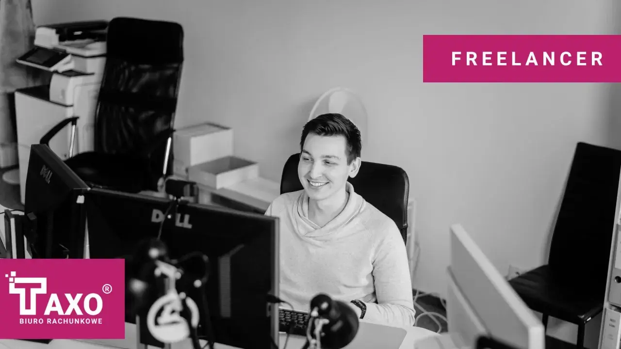 Uśmiechnięty freelancer przy biurku z komputerami. Czy freelancer musi mieć działalność gospodarczą? Zapytaj TAXO.