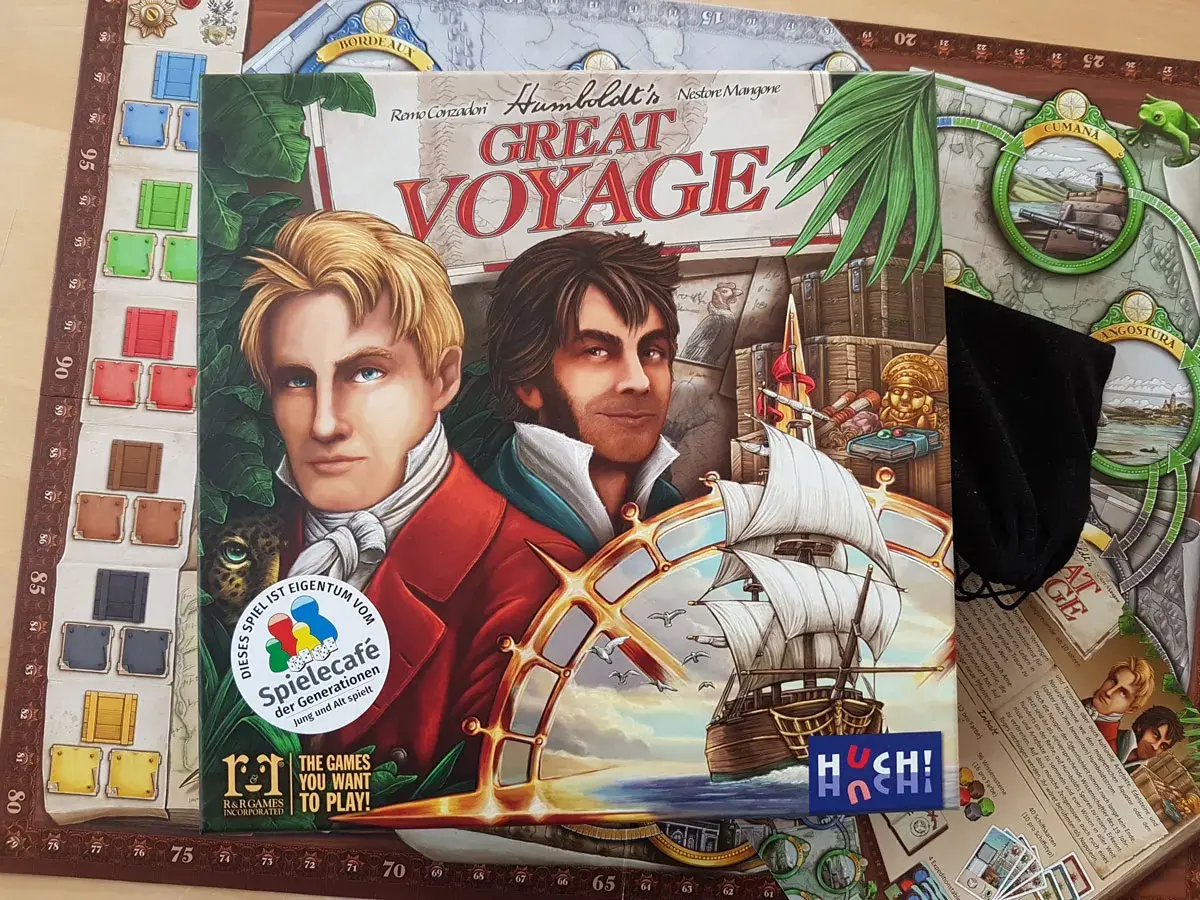 Huch! Verlag präsentiert "Great Voyage", ein Brettspiel über Entdeckungsreisen. Zwei Männer blicken entschlossen in die Ferne, ein Segelschiff gleitet über die Wellen.
