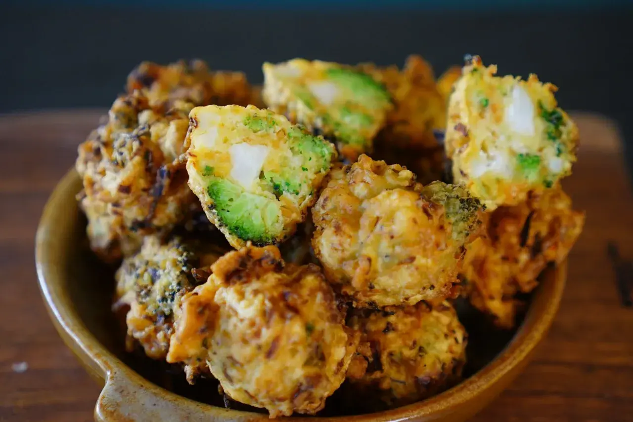Beignets de légumes croustillants, un délice doré avec des morceaux de brocoli et de pomme de terre bien visibles.