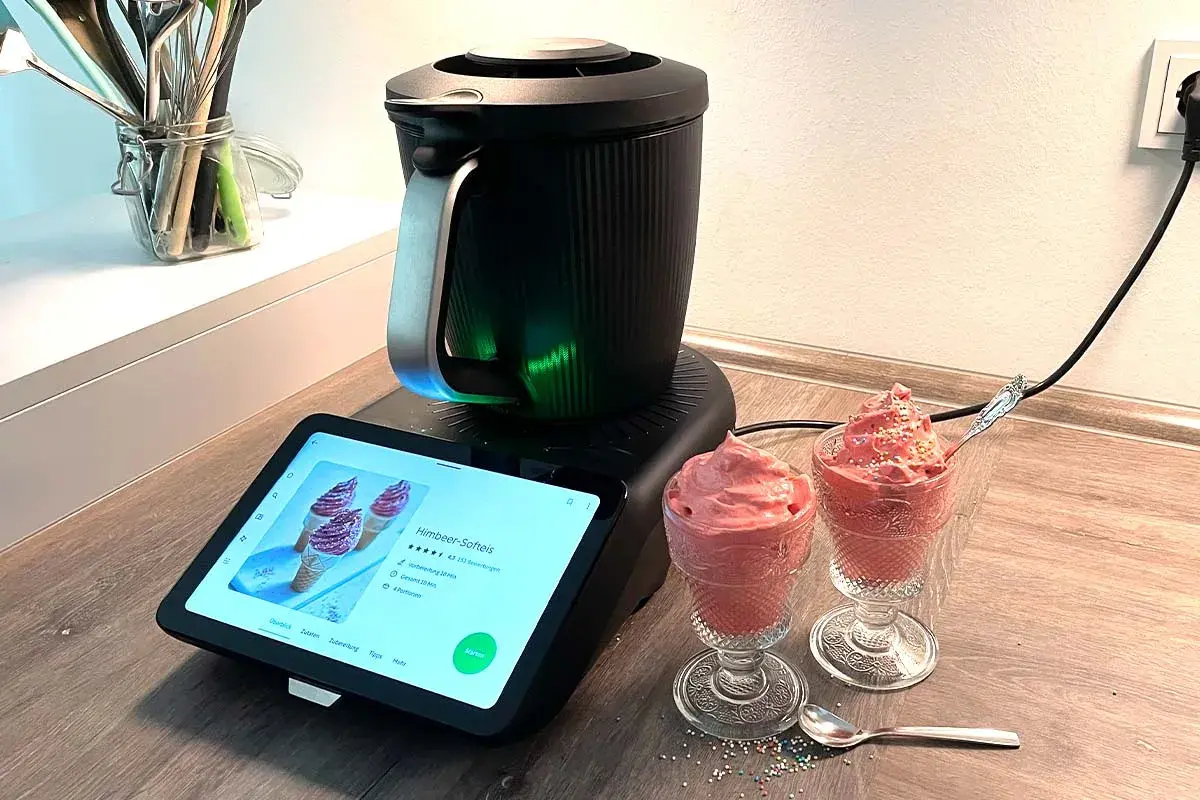 Moderne Eismaschine mit leckerem Heidelbeereis in Gläsern. Das Rezept wird auf dem Touchscreen angezeigt.
