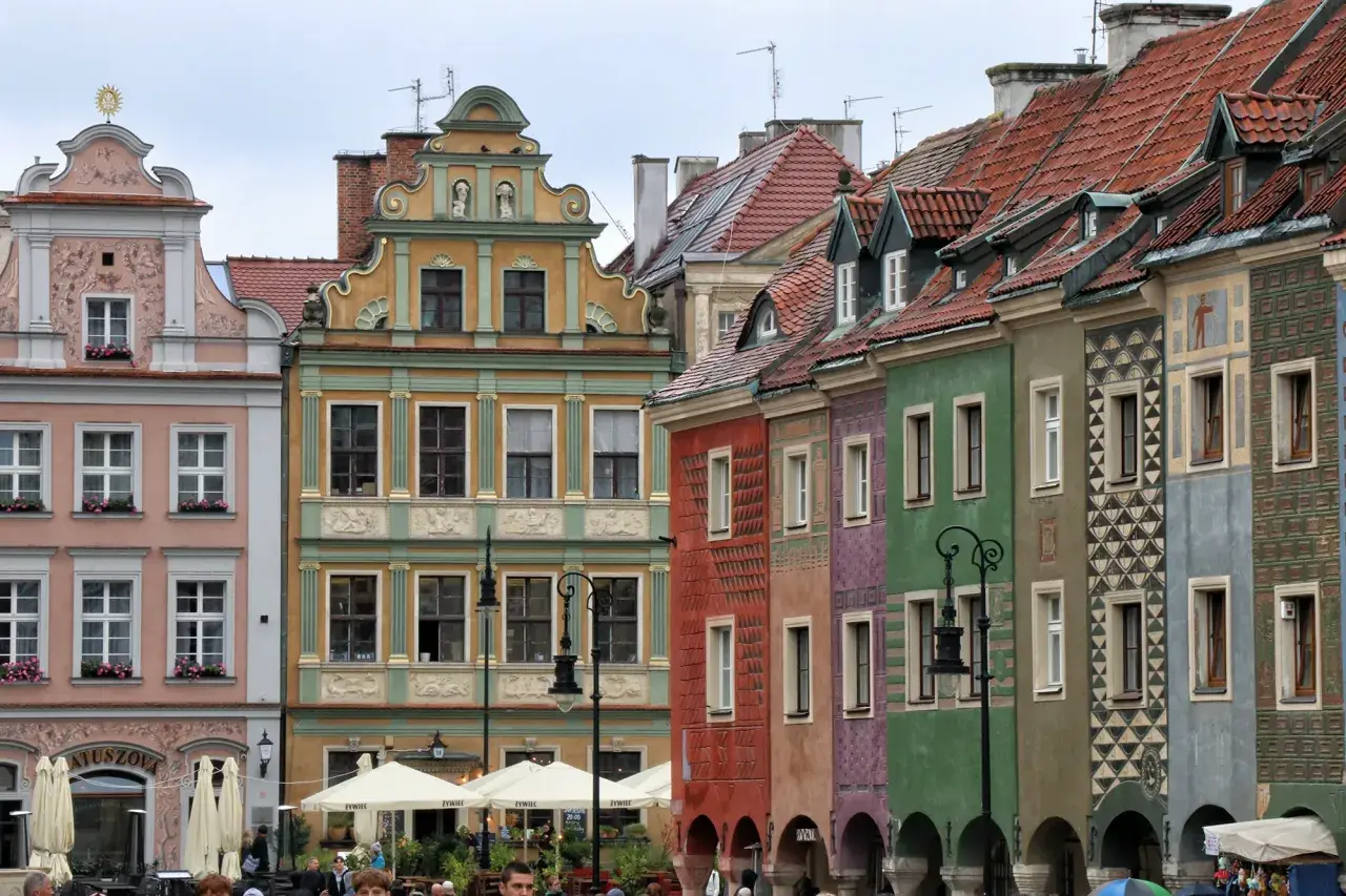 Bunte Häuser am Marktplatz in Posen, Polen. Die Fassaden sind reich verziert und die Dächer mit roten Ziegeln gedeckt.