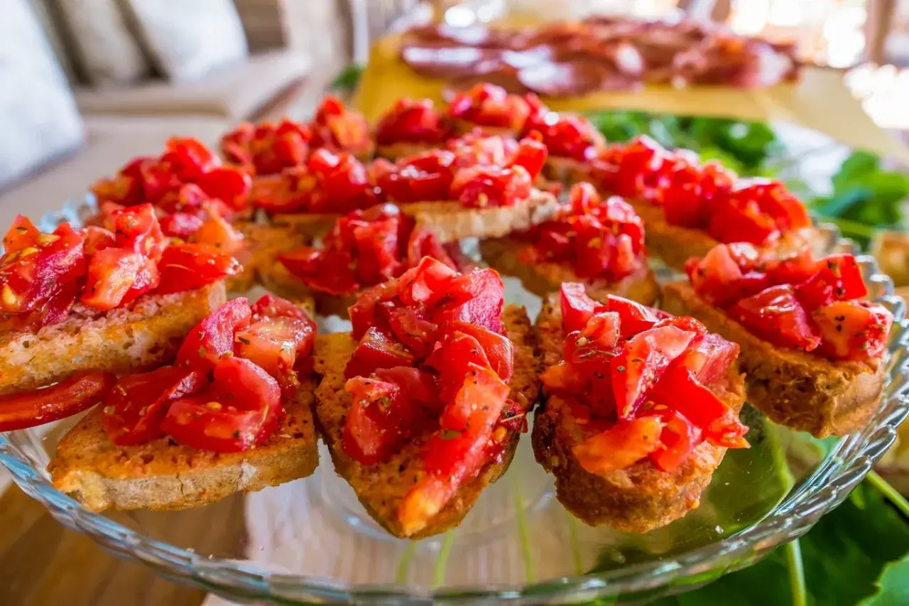 Pyszne bruschetta z pomidorami, czosnkiem i bazylią na chrupiących grzankach. Idealna przekąska na letnie przyjęcie.