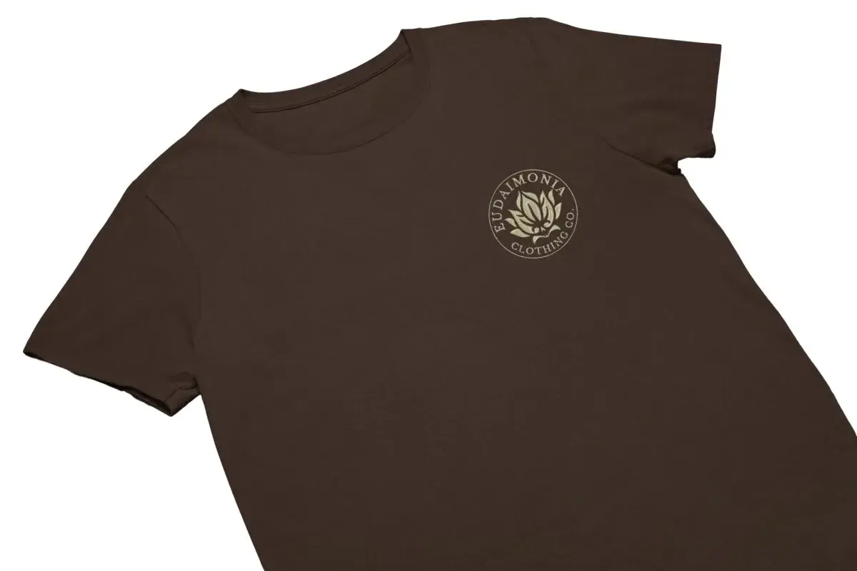 T-shirt marron avec un logo brodé d'une fleur de lotus et du texte "Eudaimonia Clothing Co.".