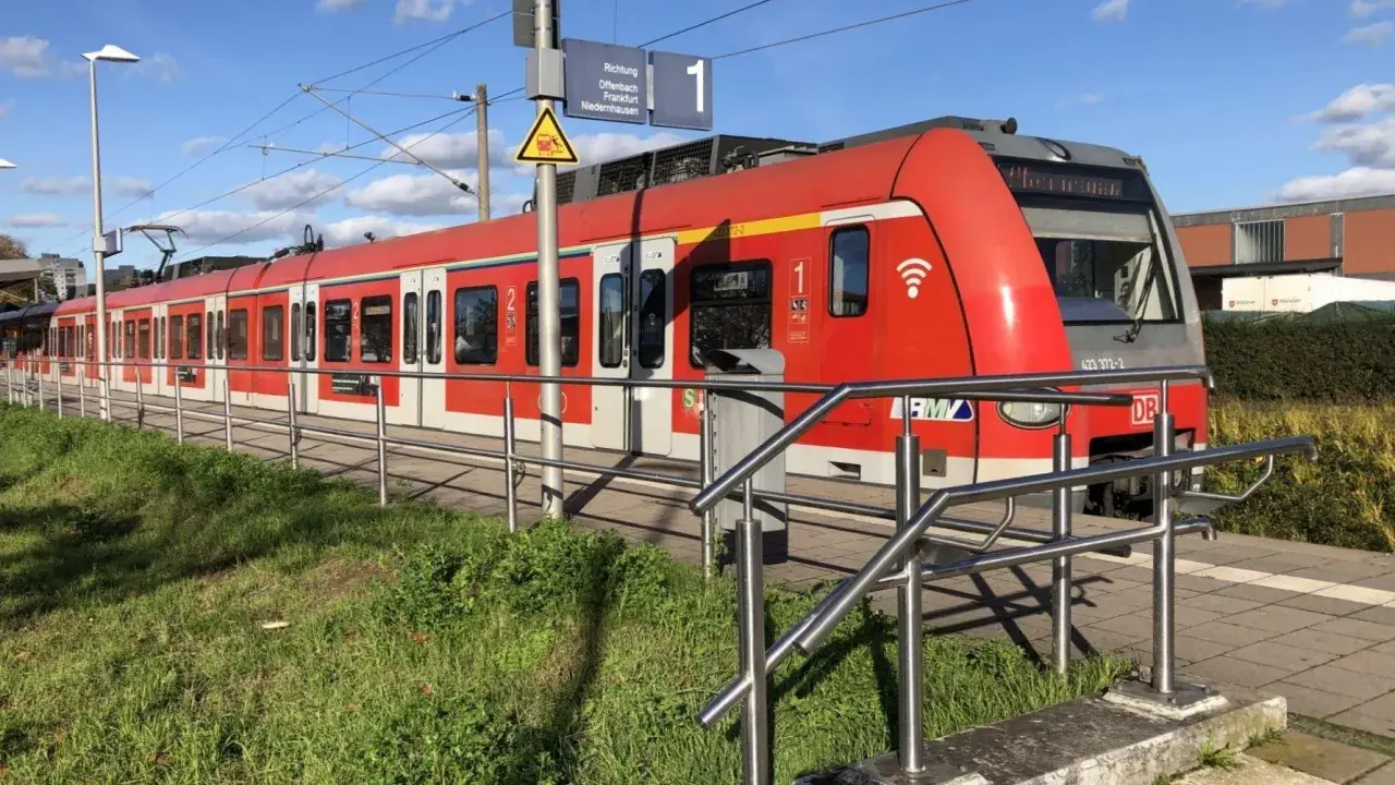 Rote S-Bahn am Bahnsteig. Informiert über den Kinderticket Preis für die Fahrt nach Offenbach, Frankfurt oder Niedernhausen.