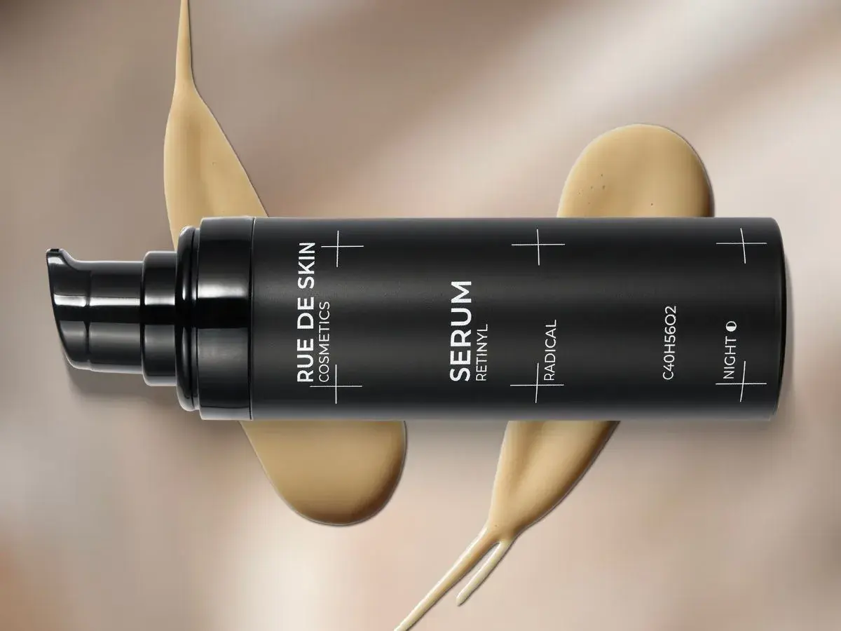 Czarny flakon serum z napisem "SERUM RETINYL". Kremowa konsystencja spływa po opakowaniu. Dowiedz się, retinol co to i jak działa.