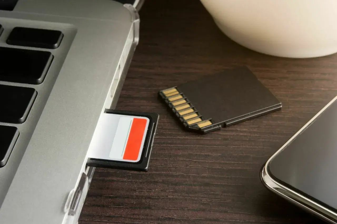 SD-Karte wird nicht erkannt in Windows 10? Ein Laptop, eine SD-Karte im Slot und eine daneben liegende Karte deuten auf ein Problem hin.