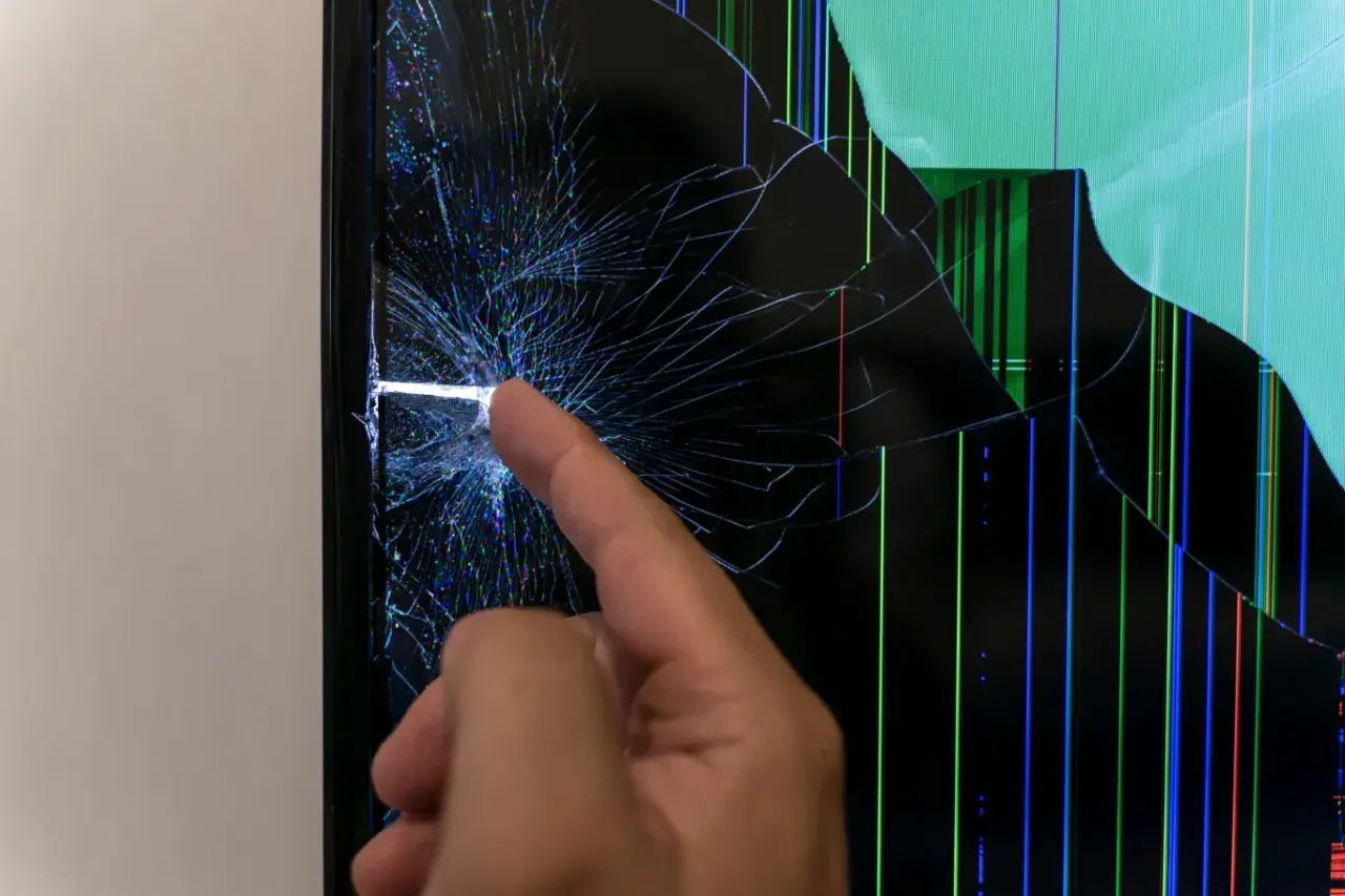 Uszkodzona matryca telewizora, widoczne pęknięcia i kolorowe linie. Czas na wymianę matrycy.