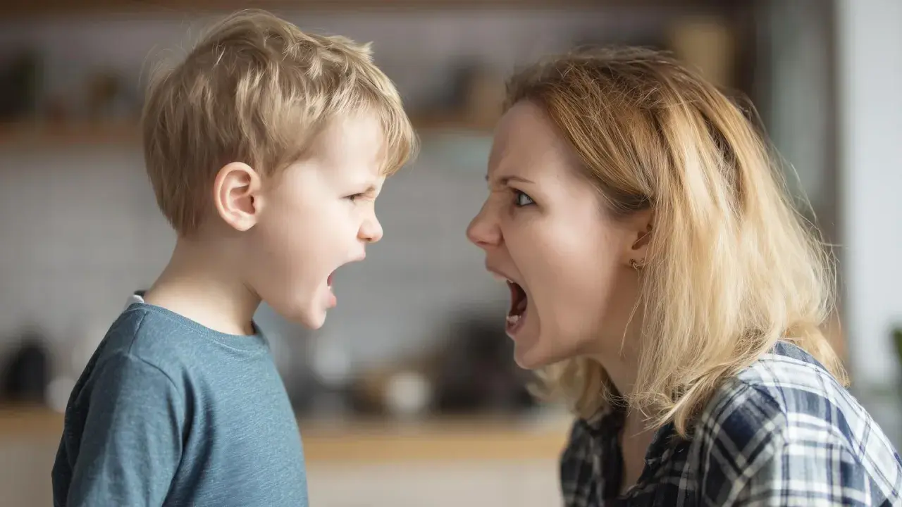 Madre e hijo se miran fijamente, ambos con la boca abierta y expresiones de enfado. ¡Qué importante es no gritar!