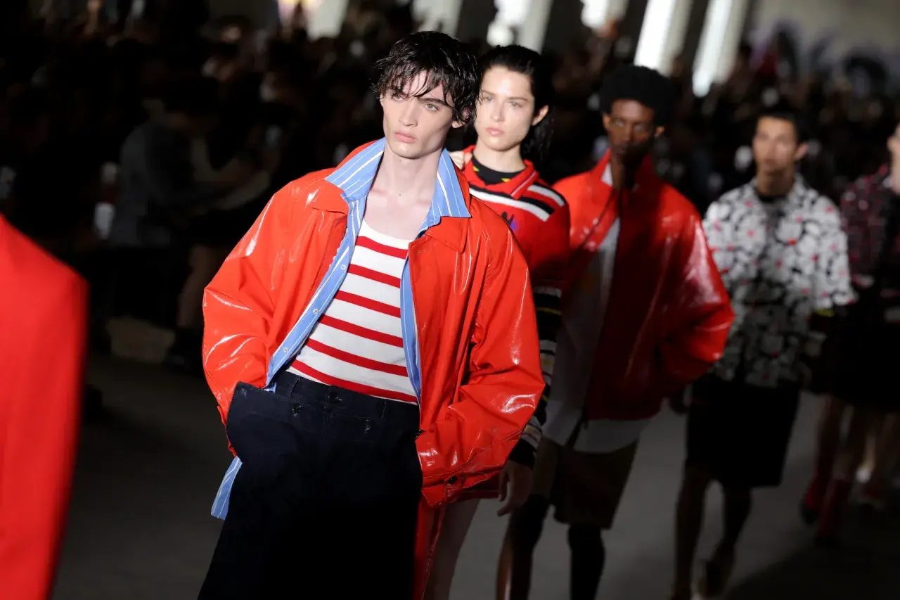 Model prezentuje pomarańczową kurtkę i pasiasty top na pokazie MSGM. To właśnie MSGM co to za marka?