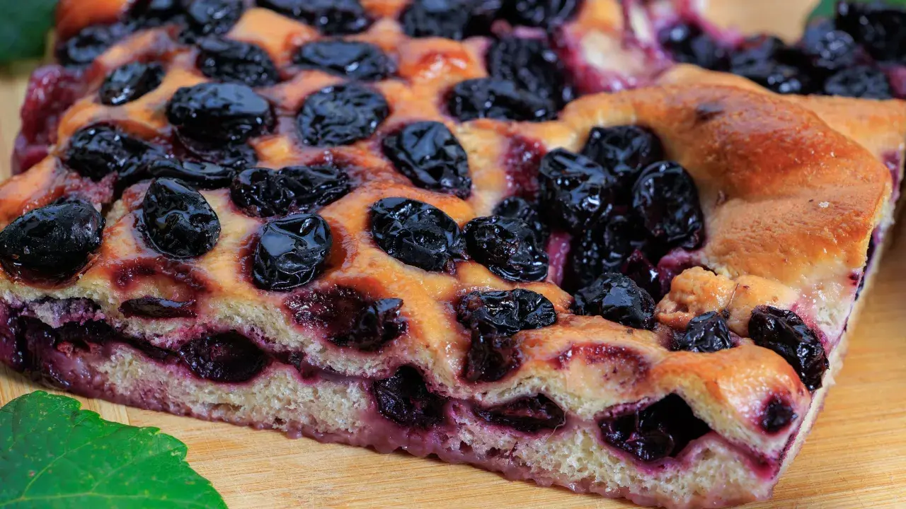 Schiacciata con l'uva, soffice e dorata, con uva succosa che crea un contrasto delizioso. Perfetta per una pausa golosa.