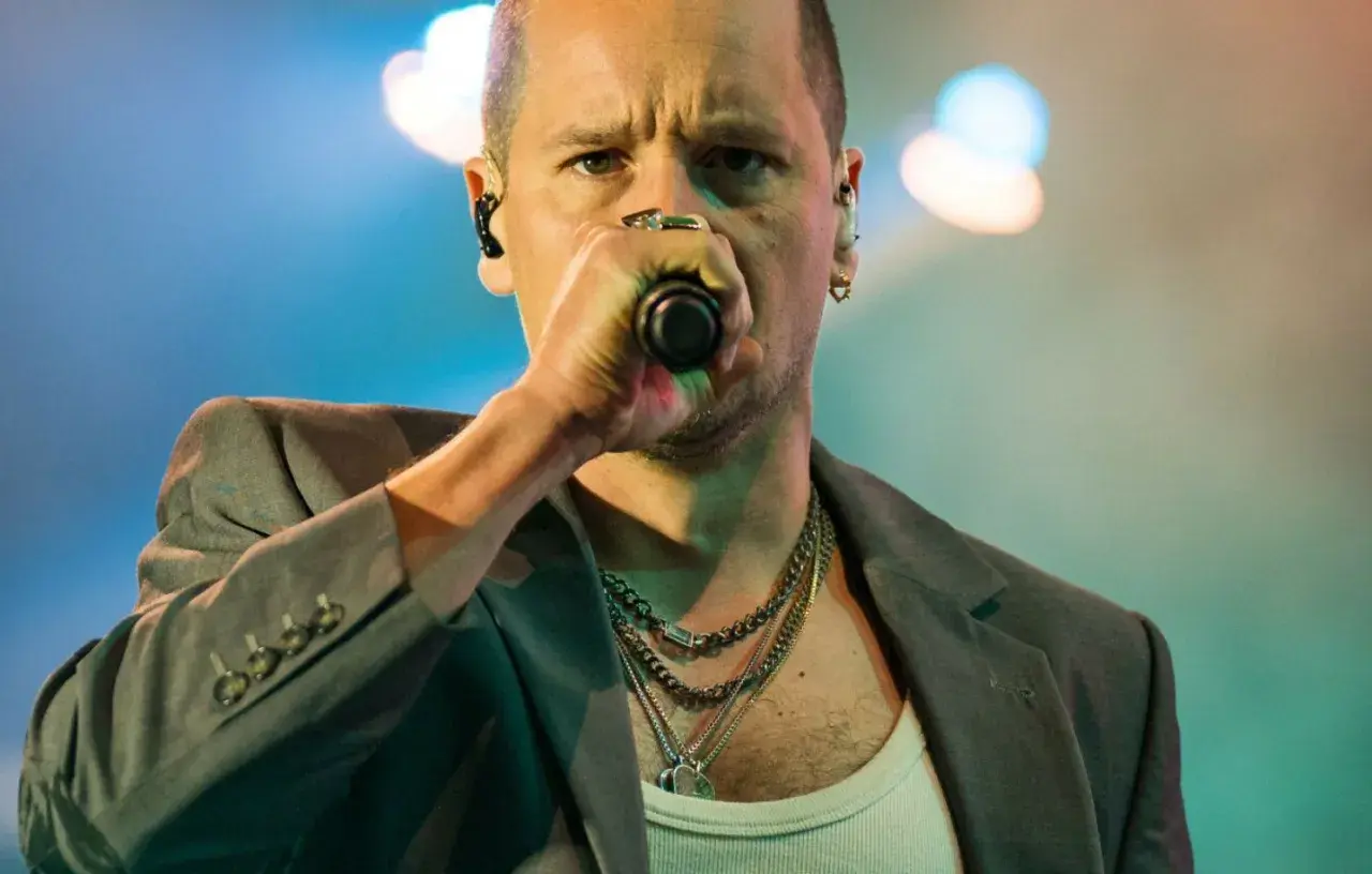 Krzysztof Zalewski śpiewa "Annuszka", w szarym garniturze i z łańcuchami na szyi.