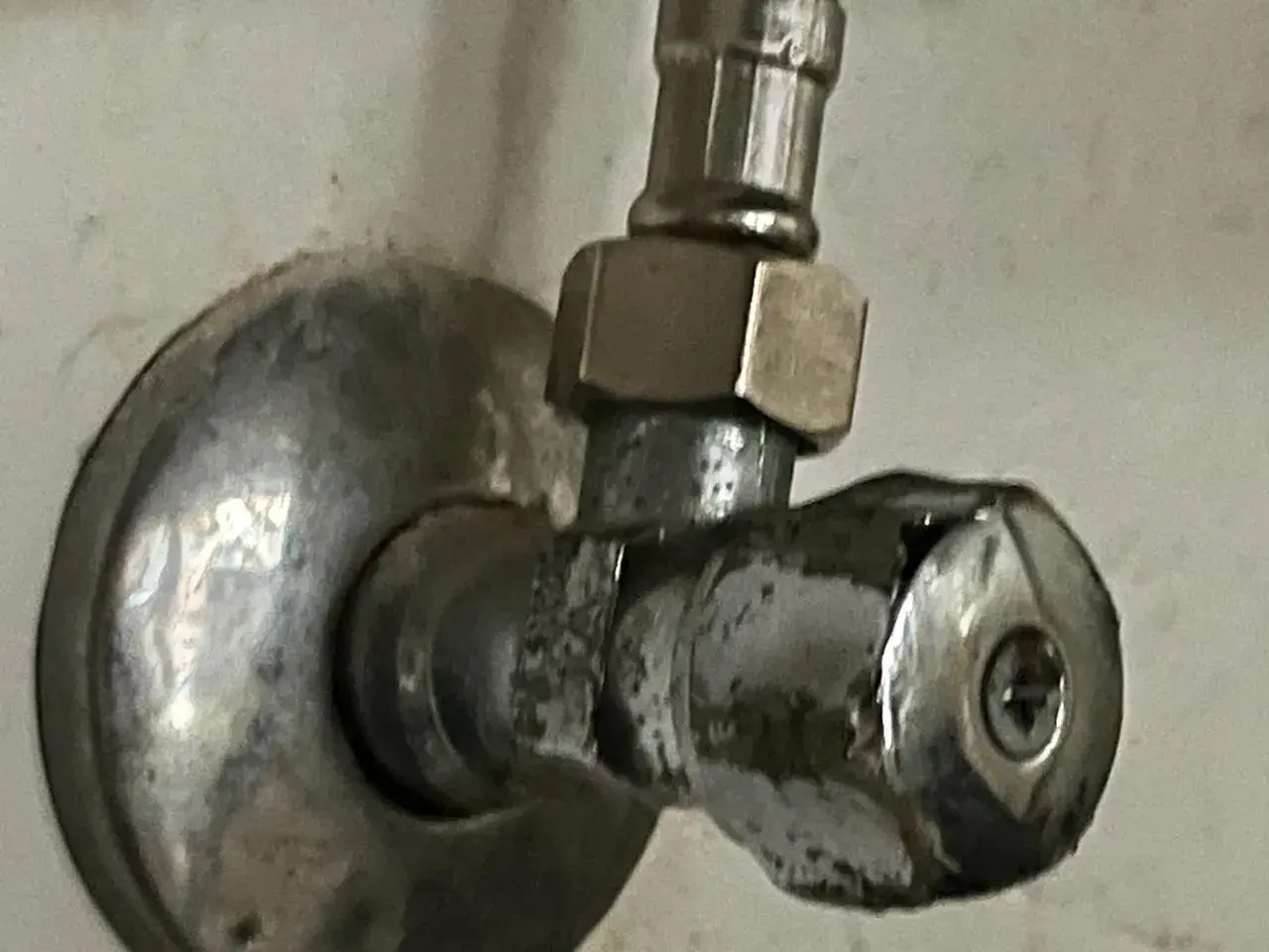 Metalowy zawór wody z uchwytem i śrubą.