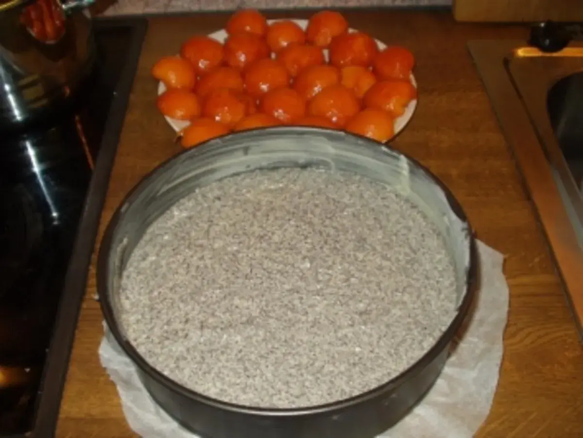 Mohnkuchen-Rezept: Mohnmasse in Springform, daneben eine Schale mit Aprikosen.