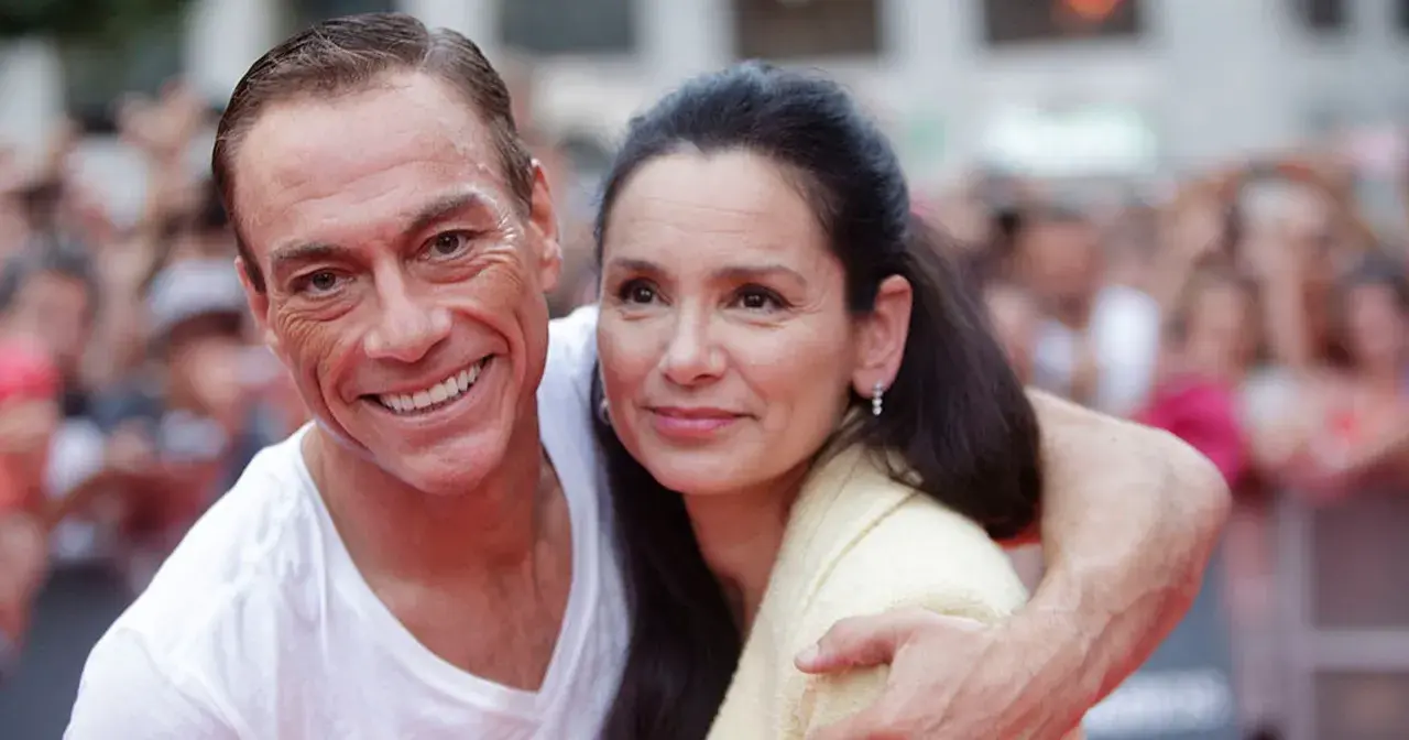 Jean-Claude Van Damme z uśmiechem obejmuje swoją żonę.