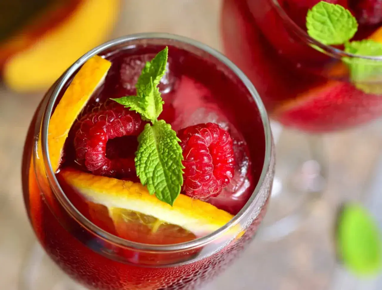 Orzeźwiająca sangria co to? Pyszny napój z malinami, pomarańczą i miętą, idealny na upalne dni.