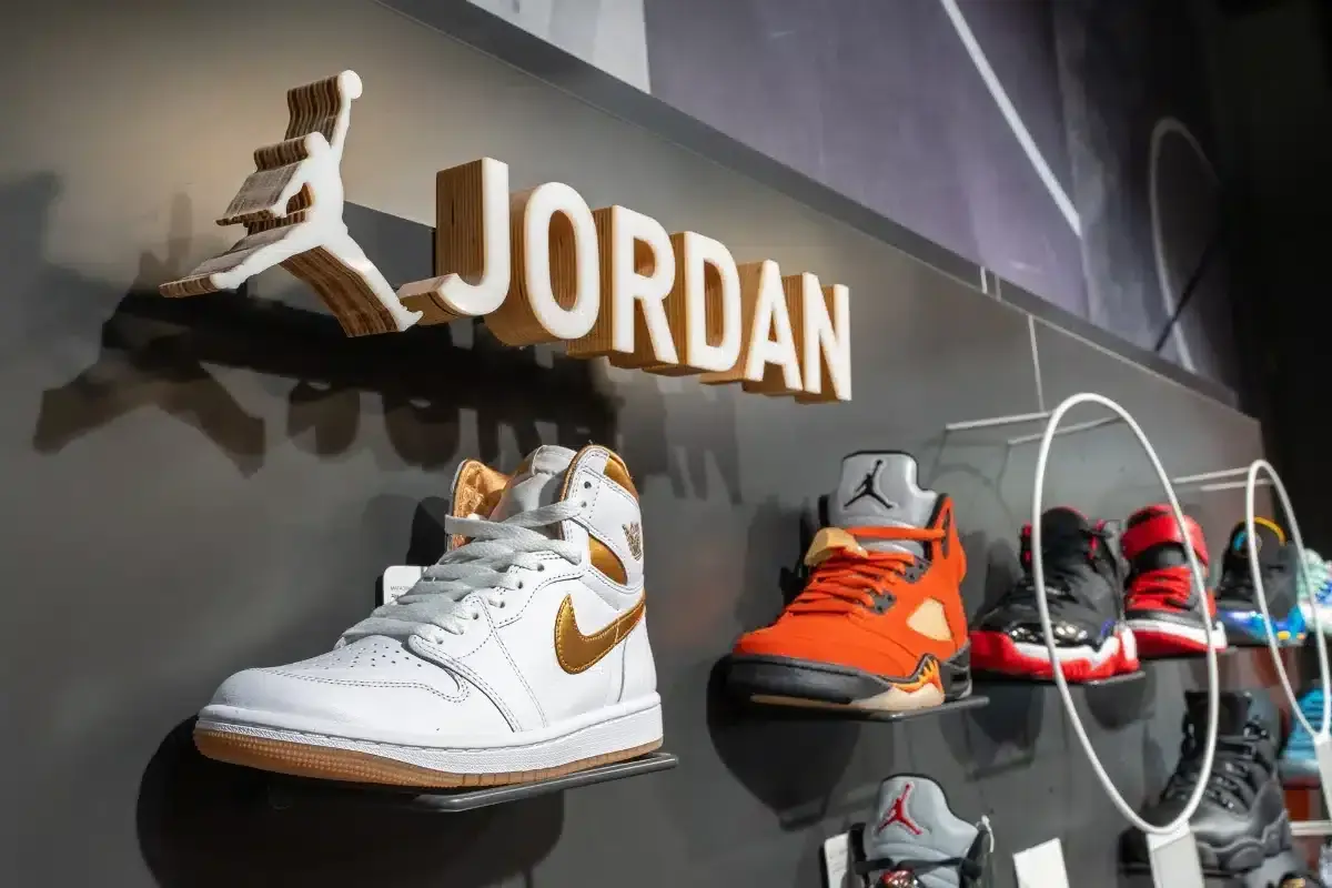 Na ścianie widnieje logo Jordan i nazwa marki. Na półkach wyeksponowane są kultowe buty Jordan Air w różnych kolorach.