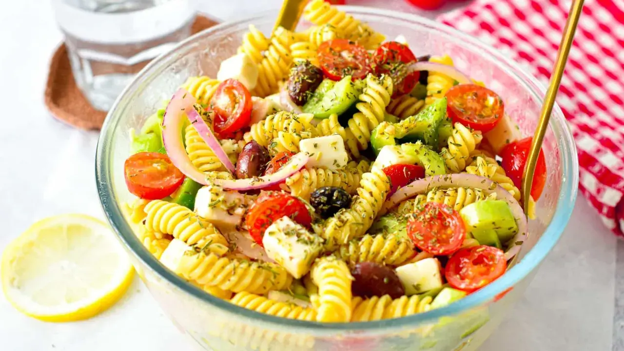 En härlig grekisk pastasallad med fusilli, körsbärstomater, fetaost, oliver och rödlök. Perfekt för en lätt lunch eller middag.