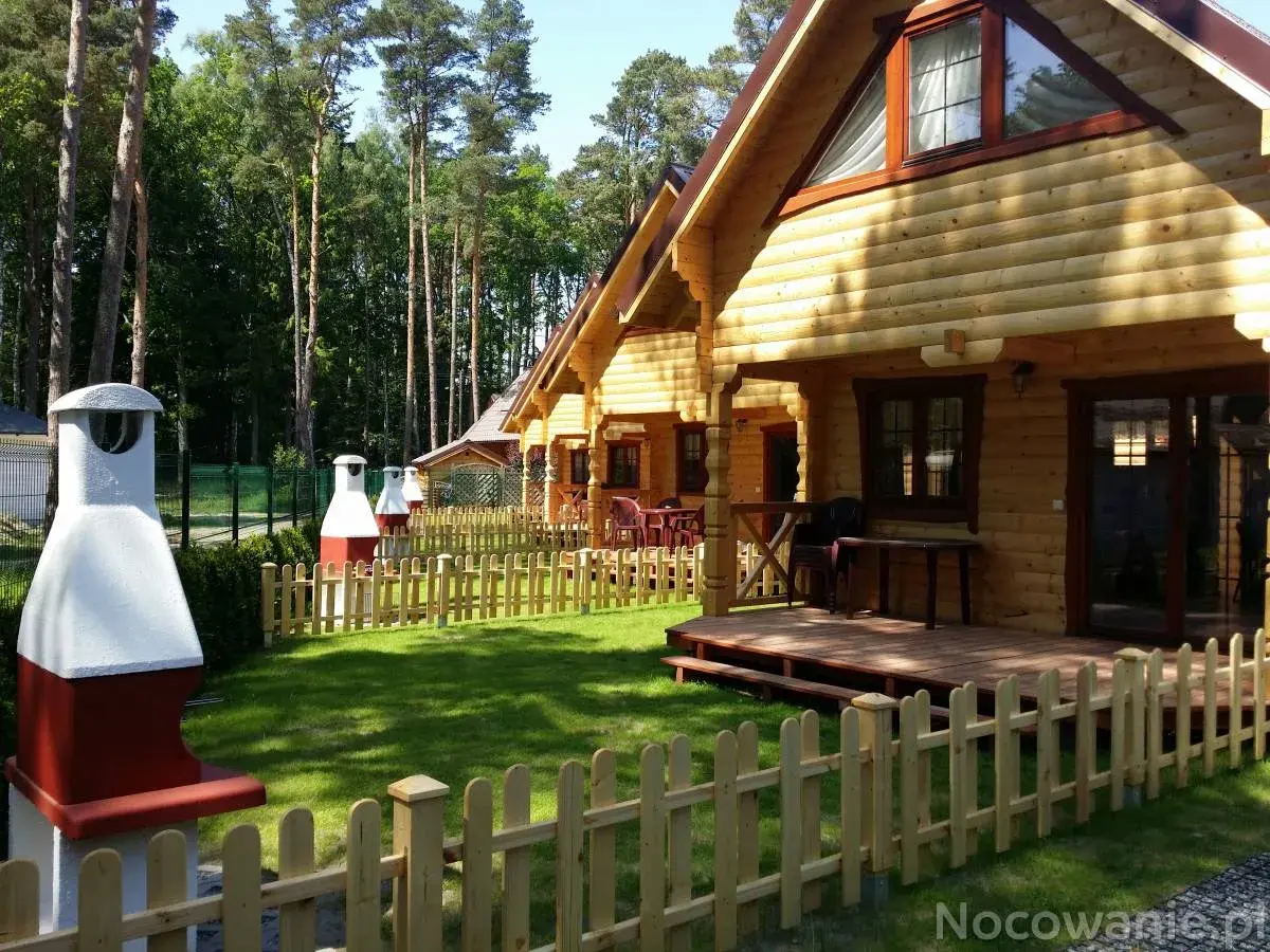 Drewniane domki nad morzem z psem czekają na gości. Piękny ogród i grill zachęcają do wypoczynku.