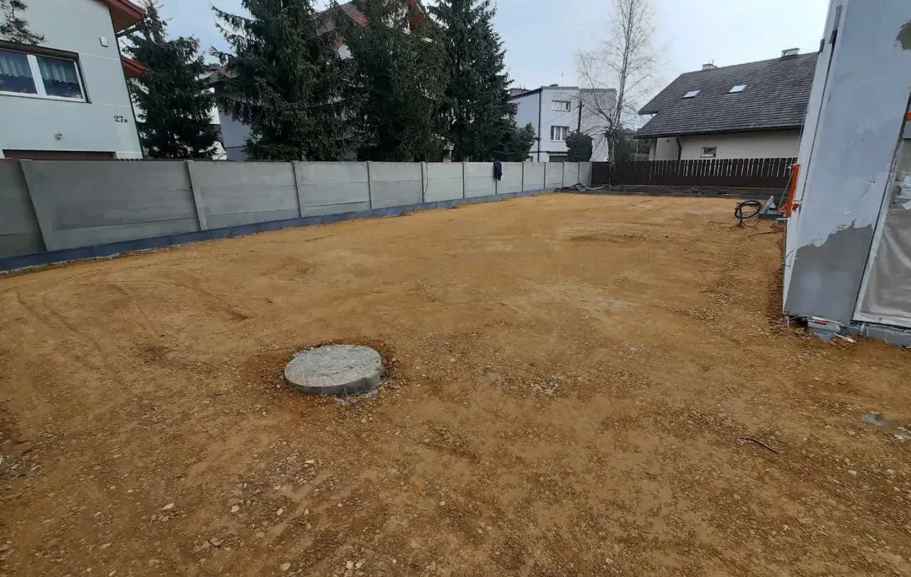 Przygotowanie terenu pod układanie kostki brukowej. Warstwy gruntu czekają na dalsze prace.