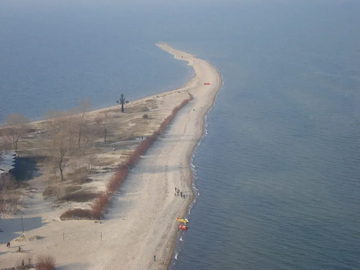 Półwysep w Rewie z krzyżem i plażą. Atrakcje turystyczne tego miejsca przyciągają spacerowiczów.
