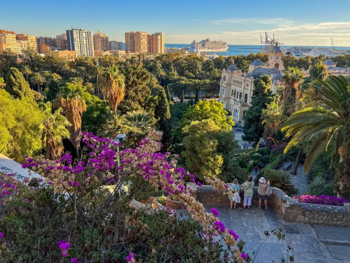 Malaga zwiedzanie: widok na park z palmami, budynki i port z rejsem. Spacer po urokliwych zakątkach miasta.