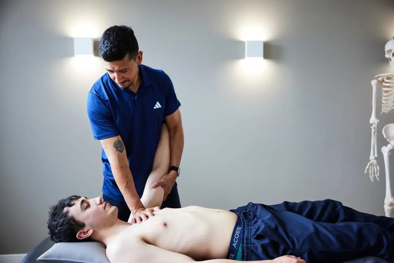 Ein Osteopath behandelt einen jungen Mann am Arm. Die Frage, wie oft Osteopathie hilft, wird hier visuell beantwortet.