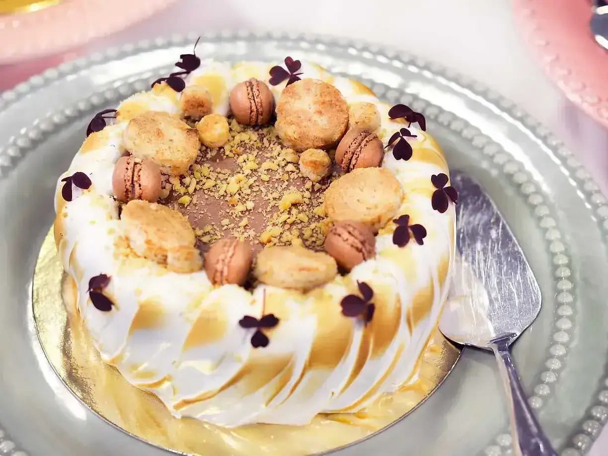 En vacker tårta med maräng och macarons, perfekt för ett speciellt tillfälle. Detta tårta recept ser utsökt ut!