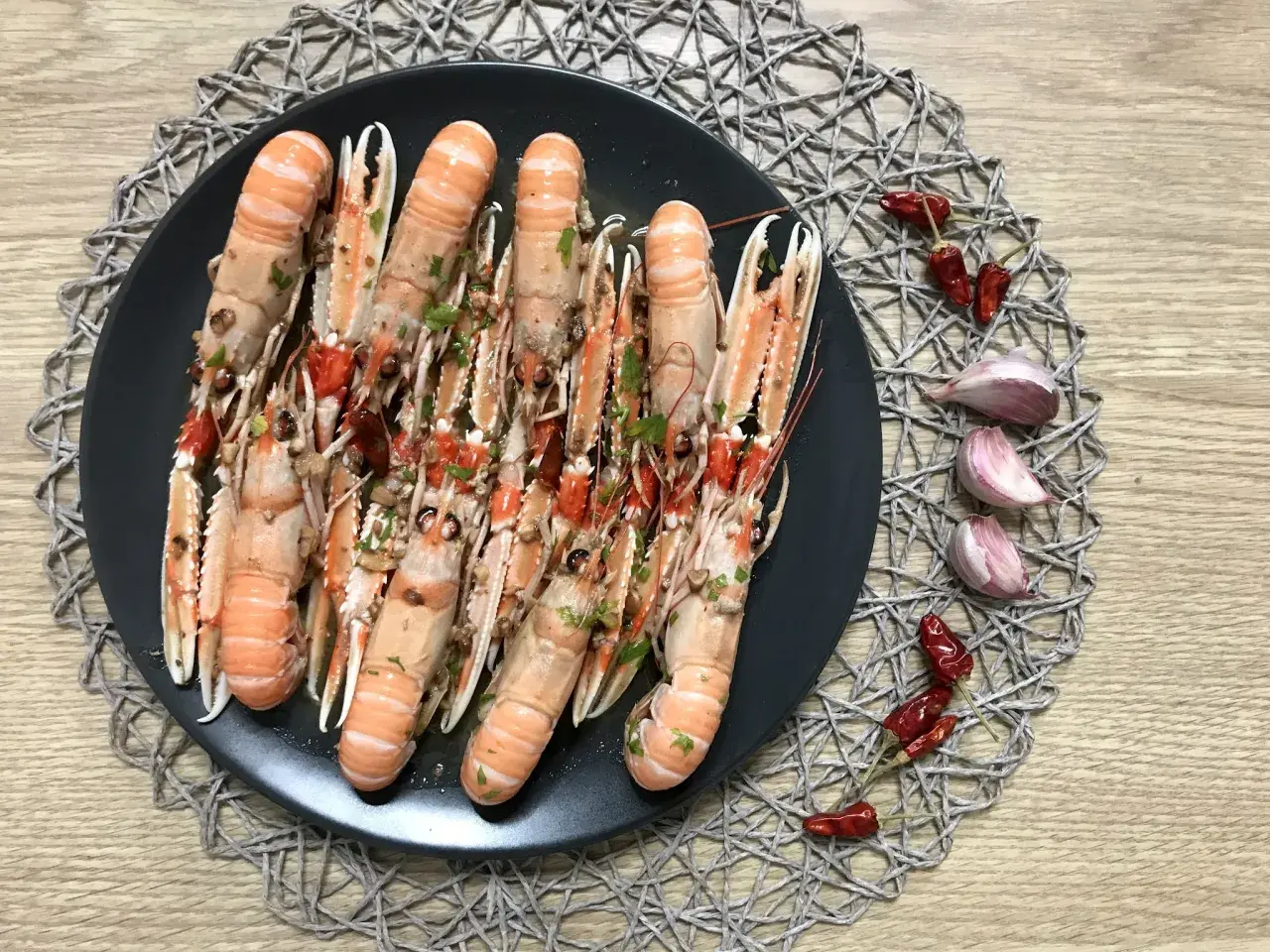Plato de cigalas al ajillo, con guindillas y ajos.