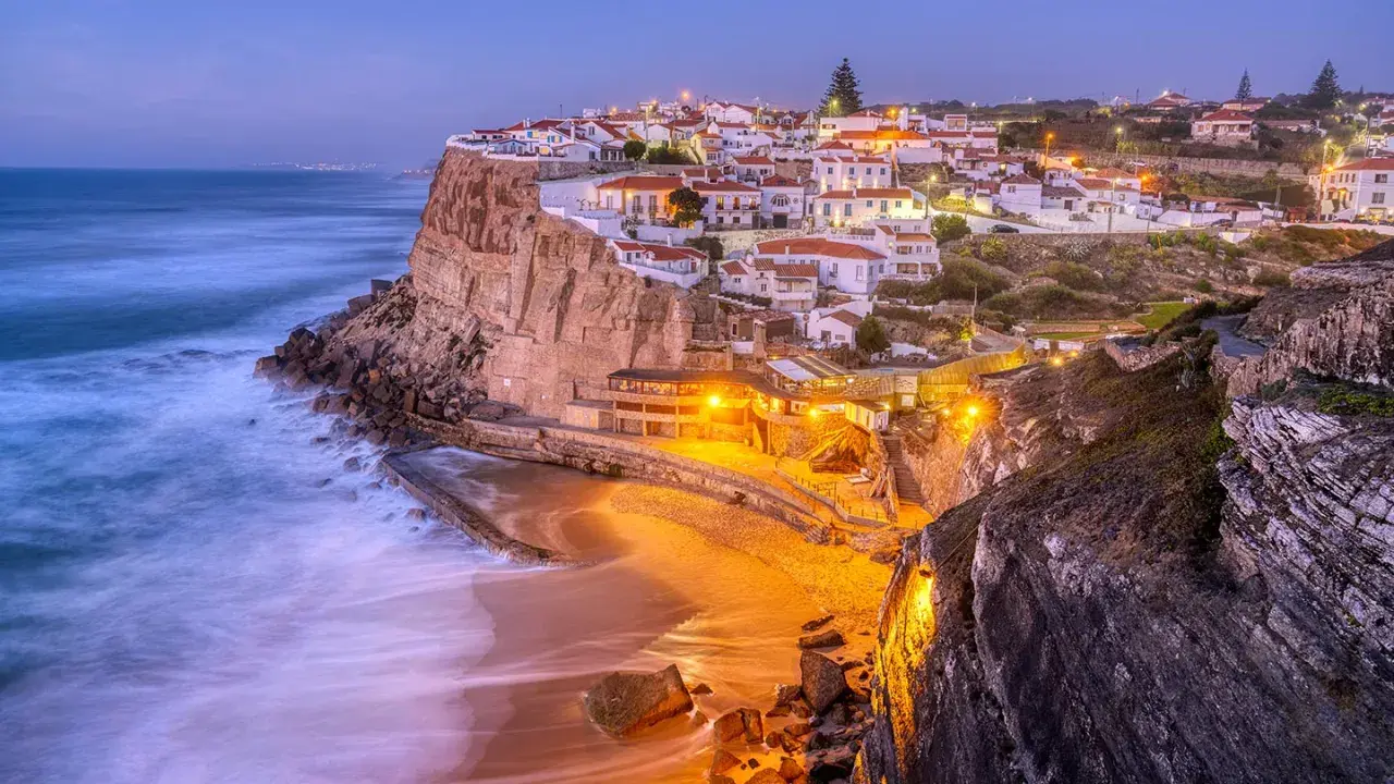 En pittoresk kuststad i Portugal, med vita hus på klipporna och en strand nedanför. Ett perfekt portugal resmål.