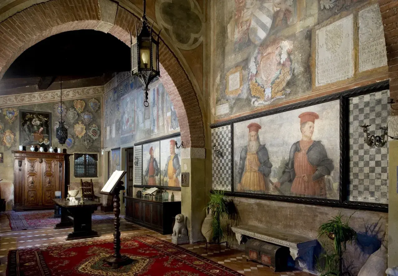 Interno del castello di Drugolo con affreschi storici, ritratti di nobili e arredi antichi.