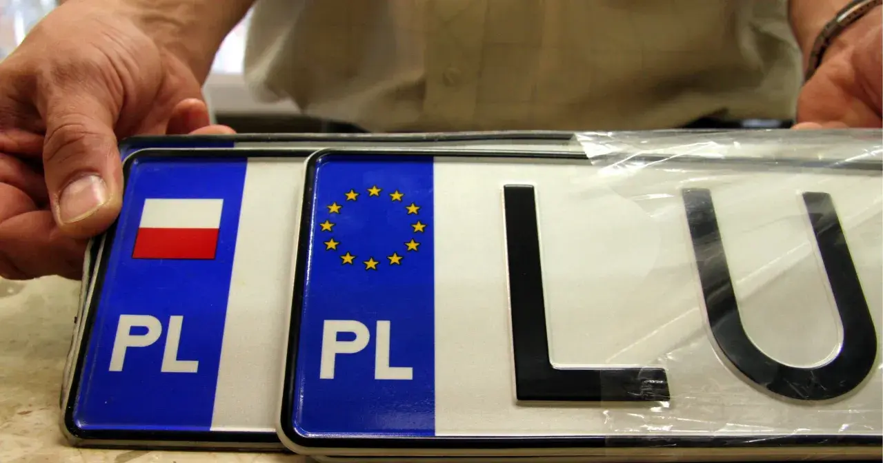 Nowy motocykl czeka na rejestrację. Dwie tablice rejestracyjne PL, jedna z flagą Polski, druga z gwiazdkami UE.