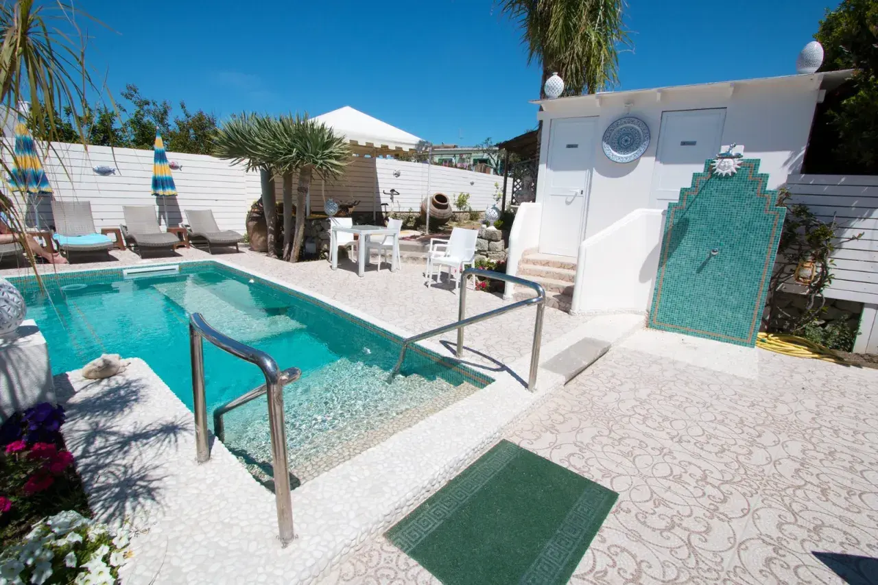 Piscina e doccia esterna in un'area relax, ideale per chi cerca "park hotel la villa ischia recensioni" per una vacanza indimenticabile.