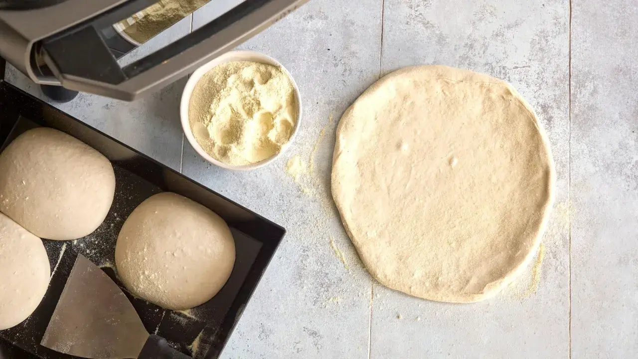 Förberedelser för pizza: poolish pizzadeg, mjöl i skål och degbollar i form.