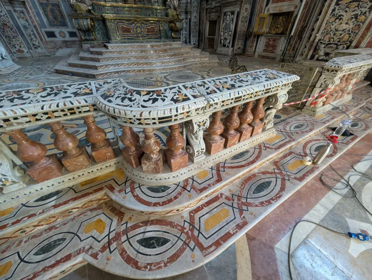Interno di chiesa con pavimenti e balaustre decorate con vari tipi di marmi antichi, in stile barocco.