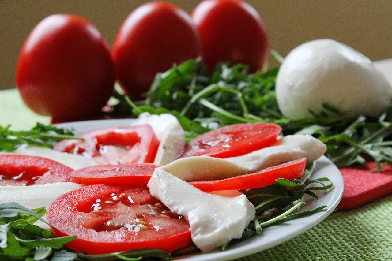 Caprese con burrata, pomodori freschi e rucola. Un piatto leggero e gustoso, perfetto per chi cerca un'alimentazione sana, anche in gravidanza.
