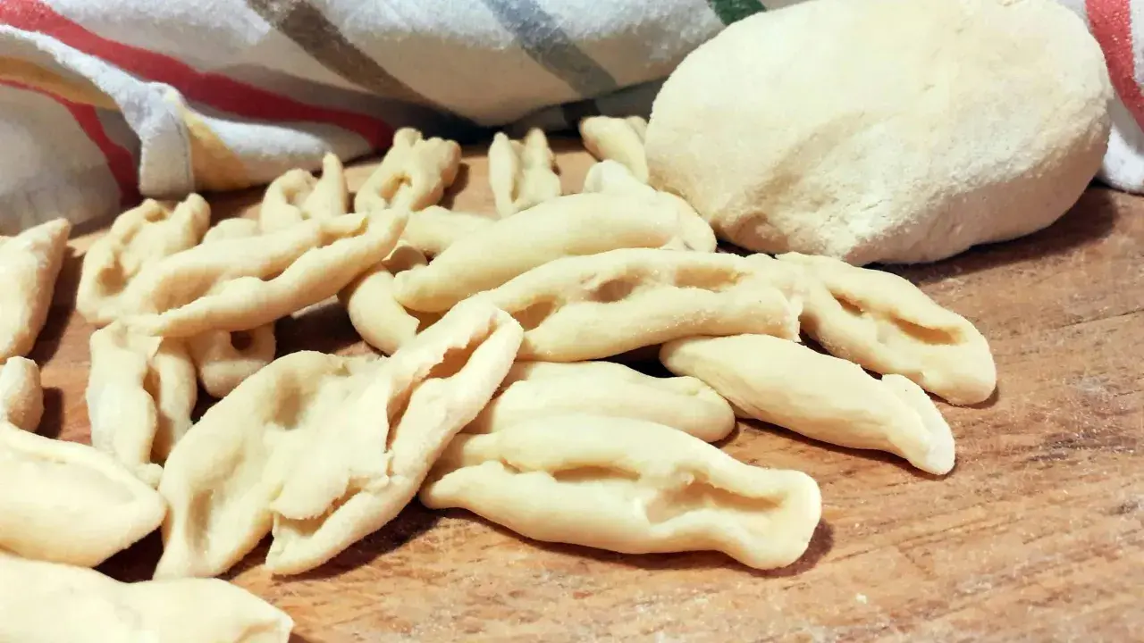 Strascinati pugliesi freschi, pronti per essere cucinati, su un tagliere di legno.