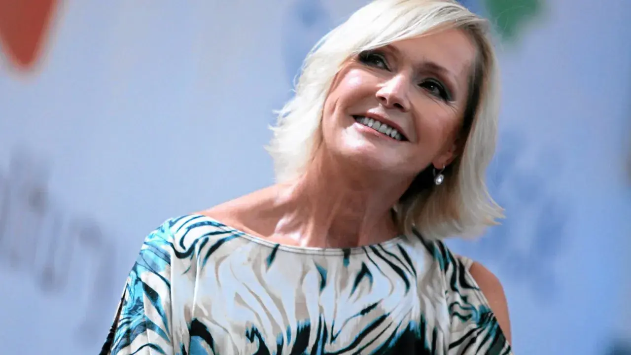 Uśmiechnięta Helena Vondráčková w bluzce z wzorem przypominającym zebrę, z blond włosami i kolczykiem w uchu.