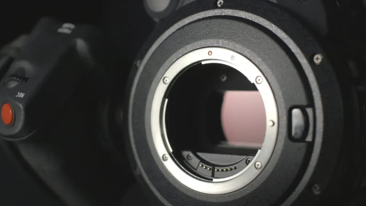 Dettaglio obiettivo di una fotocamera ad alta megapixel, con il pulsante REC visibile.