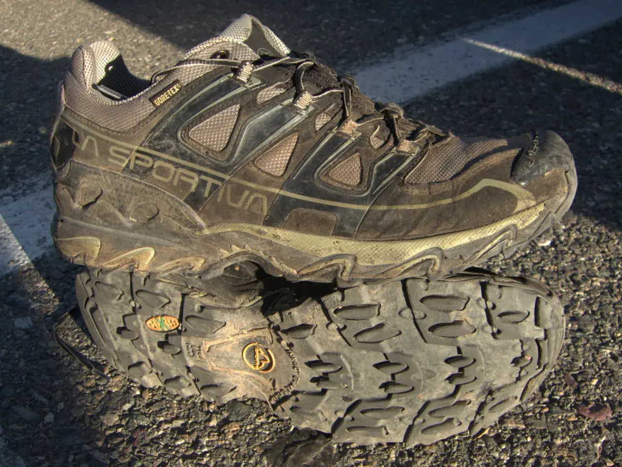 A muddy La Sportiva hiking shoe with "GORE-TEX" branding, indicating its waterproof and breathable meaning for shoes.